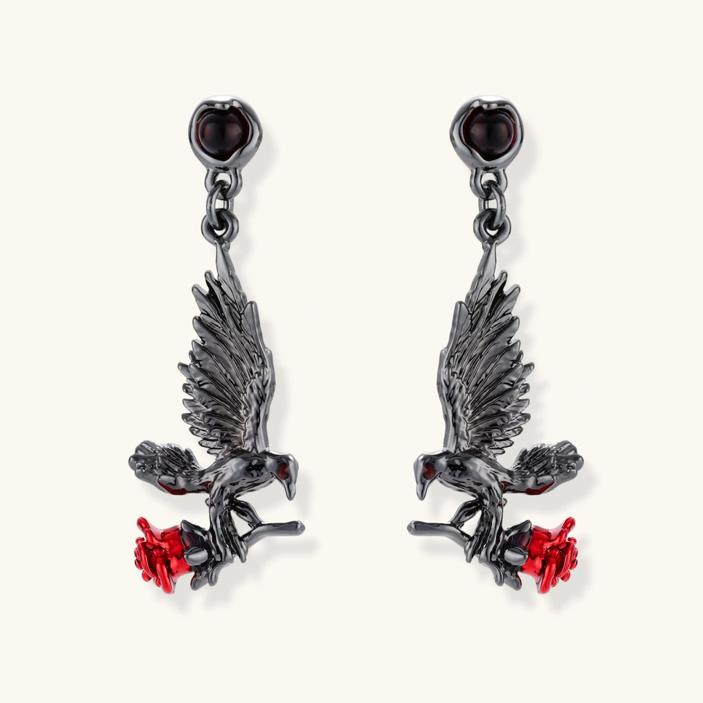 Dark gunmetal jewelry set featuring detailed raven pendants carrying red enamel roses with layered pearl and chain necklaces