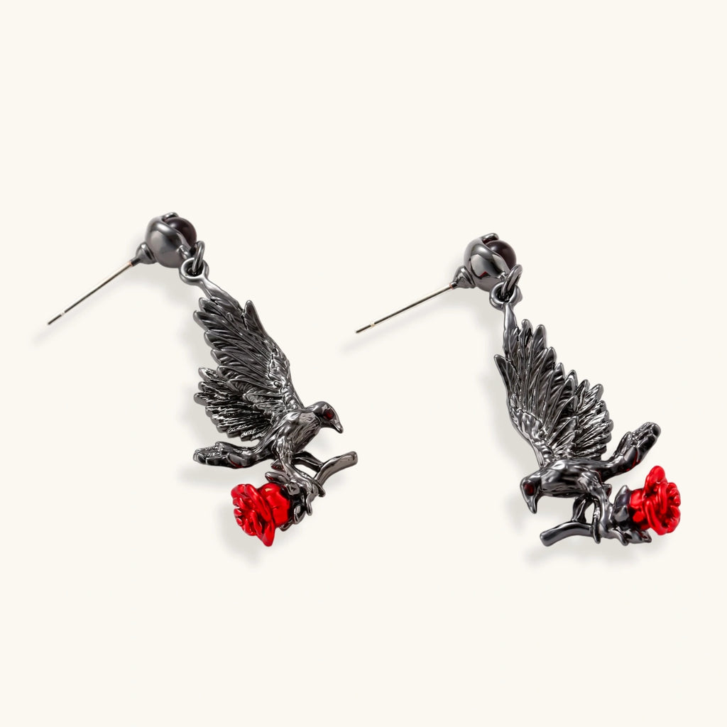 Dark gunmetal jewelry set featuring detailed raven pendants carrying red enamel roses with layered pearl and chain necklaces